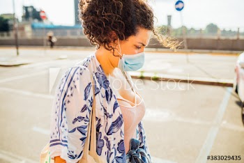 Young woman wearing medical mask while walking on street