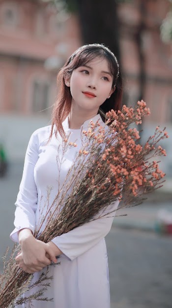 Young Woman with Flowers Posing Outdoors