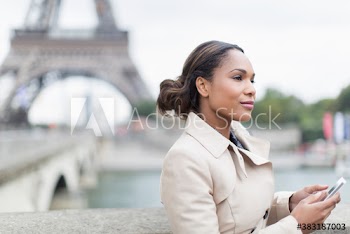 Young woman with smart phone, Eiffel Tower, Paris, France