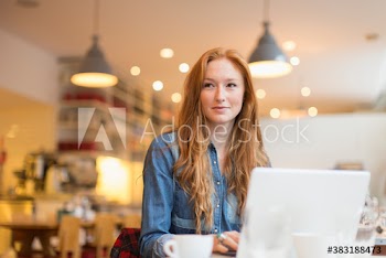 Young woman working at laptop in cafe