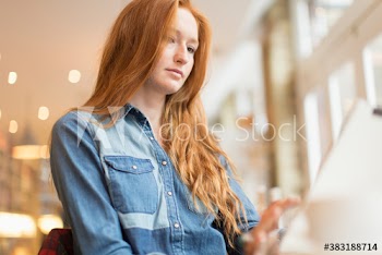 Young woman working at laptop in cafe