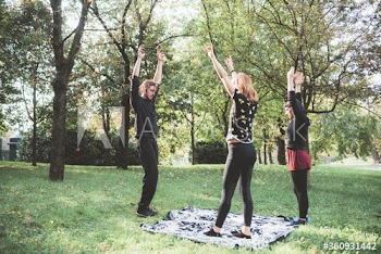 Young women exercising with personal trainer in park