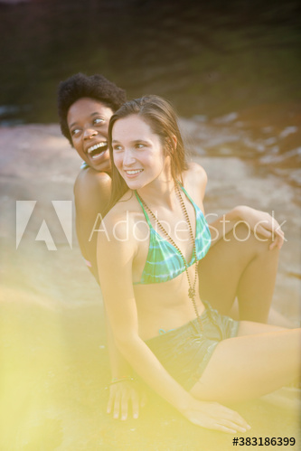 Young women friends in bathing suits at lakeside
