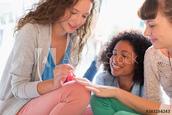 Young women friends painting fingernails with nail polish