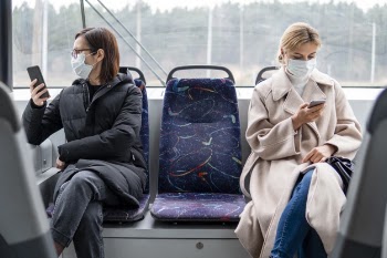 Young women using public transport with surgical mask Free Photo