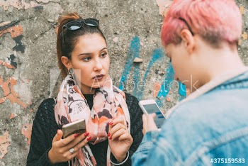 Young women using smartphone on street