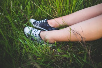 Youth sneakers on girl legs on grass