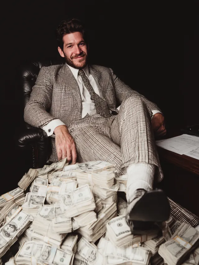 Businessman Sitting on Piles of Cash