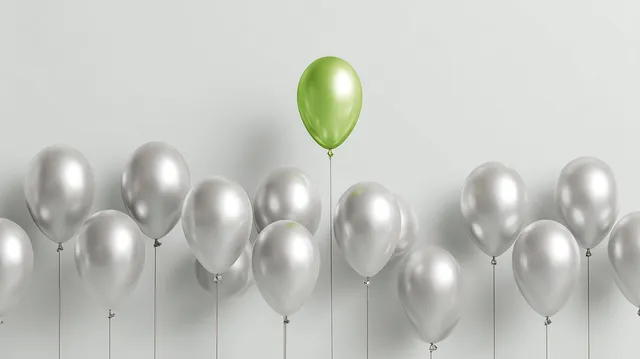 Green Balloon Rising Above Silver Balloons