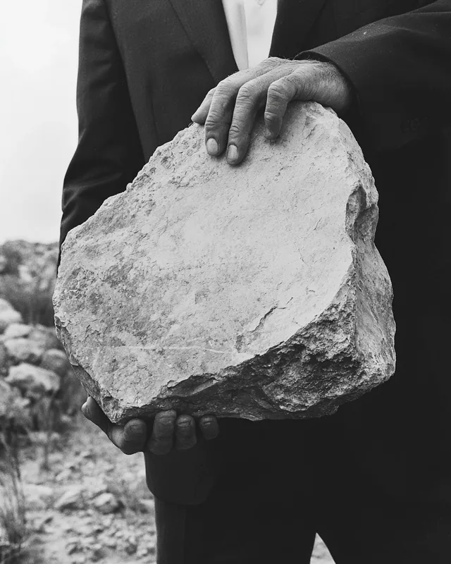 Surreal Burden: A Man Carrying a Stone